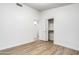 Spacious bedroom with modern wood flooring, a closet, and access to the bathroom at 6439 W Adobe Dr, Glendale, AZ 85308