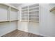 Walk-in closet featuring built-in shelving and wood flooring, offering ample storage space at 6439 W Adobe Dr, Glendale, AZ 85308