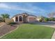 Well-kept single-story home showcases desert landscaping, a two-car garage, and a tidy front lawn at 6439 W Adobe Dr, Glendale, AZ 85308