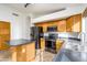 Bright kitchen featuring stainless steel appliances, wood cabinets, and a dark countertop island at 6439 W Adobe Dr, Glendale, AZ 85308