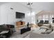 Staged living room featuring vaulted ceilings, wood floors, modern decor, and plantation shutters at 6439 W Adobe Dr, Glendale, AZ 85308