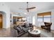 Staged living room featuring a sectional sofa, wood tile flooring, breakfast nook, and modern light fixtures at 6439 W Adobe Dr, Glendale, AZ 85308