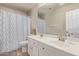 Bright bathroom with double sinks, neutral walls, and decorative shower curtain at 6785 W Tether Trl, Peoria, AZ 85383