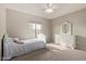 Well-lit bedroom with a white bed frame, neutral walls, and a charming dresser with a mirror at 6785 W Tether Trl, Peoria, AZ 85383