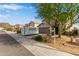 Suburban two-story home with a gravel front yard, mature tree, and a two-car garage near a sidewalk at 6785 W Tether Trl, Peoria, AZ 85383