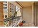 This balcony has decorative iron railings and a view of landscaped common space with mature trees at 7181 E Camelback Rd # 208, Scottsdale, AZ 85251