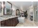 Luxurious primary bathroom featuring a soaking tub, granite countertops, and decorative sconces at 7181 E Camelback Rd # 208, Scottsdale, AZ 85251