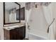 Bathroom with vanity, bathtub, white tile walls, and decorative mirror and curtains at 7181 E Camelback Rd # 208, Scottsdale, AZ 85251