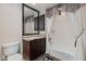 Bathroom featuring a dark vanity, granite countertops, decorative mirror, and shower with curtain at 7181 E Camelback Rd # 208, Scottsdale, AZ 85251