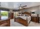 Spacious bedroom featuring a large bed, hardwood furniture, balcony access, and natural lighting at 7181 E Camelback Rd # 208, Scottsdale, AZ 85251