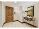 Inviting entryway featuring a wooden door, marble floors, and an elegant console table with decorative art at 7181 E Camelback Rd # 208, Scottsdale, AZ 85251