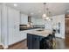 Modern kitchen featuring white cabinets, dark countertops, a large island, and stainless steel appliances at 7181 E Camelback Rd # 208, Scottsdale, AZ 85251