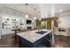 Modern kitchen island with granite countertop, dark cabinets, seating, and open floor plan at 7181 E Camelback Rd # 208, Scottsdale, AZ 85251