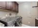 Modern laundry room with a stainless steel washer and dryer and granite countertops at 7181 E Camelback Rd # 208, Scottsdale, AZ 85251