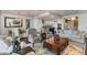 Expansive living area flowing to kitchen and dining, featuring hardwood floors and ample seating at 7181 E Camelback Rd # 208, Scottsdale, AZ 85251