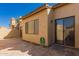 Backyard exterior showcasing a stucco wall, a window, a sliding glass door, and a brick patio at 7955 E Chaparral Rd # 120, Scottsdale, AZ 85250