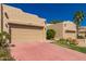 Single-story stucco home with a two-car garage and a tile driveway in a desert landscape at 7955 E Chaparral Rd # 120, Scottsdale, AZ 85250