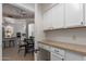 Pantry with white cabinets, counter space, and open view to kitchen and dining area at 7955 E Chaparral Rd # 120, Scottsdale, AZ 85250