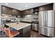 Modern kitchen features stainless steel appliances, dark cabinetry, granite countertops, and a center island at 8107 E Mitchell Dr, Scottsdale, AZ 85251