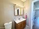 Comfortable half-bathroom featuring tiled floors, vanity with mirror and a traditional toilet at 903 S Mineshaft Dr, Apache Junction, AZ 85119