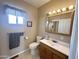 Comfortable half-bathroom featuring tiled floors, window, traditional toilet and vanity with storage at 903 S Mineshaft Dr, Apache Junction, AZ 85119