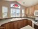 Close-up of a kitchen sink with wood cabinets and a bright window at 903 S Mineshaft Dr, Apache Junction, AZ 85119