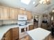 Bright kitchen features wood cabinets, white appliances, neutral countertops, and center island at 903 S Mineshaft Dr, Apache Junction, AZ 85119