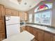 Well-equipped kitchen with wood cabinets, white appliances, and natural light at 903 S Mineshaft Dr, Apache Junction, AZ 85119