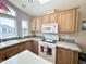 Bright kitchen featuring a double sink, white appliances and ample wood cabinetry at 903 S Mineshaft Dr, Apache Junction, AZ 85119