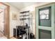 Office nook features a black desk with shelving, cabinet, black chair, and a bright green exterior door at 9828 E Pueblo Ave # 113, Mesa, AZ 85208