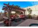 Charming backyard pergola with seating, fire pit, and lush landscaping at 10746 W Desert Elm Ln, Peoria, AZ 85383