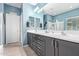 Modern bathroom with double sinks, vanity, and tiled floors, complemented by fresh blue walls at 10746 W Desert Elm Ln, Peoria, AZ 85383