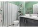 Bathroom featuring green walls, white toilet and shower with a vanity in the foreground at 10746 W Desert Elm Ln, Peoria, AZ 85383