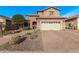 Beautiful two-story home with a spacious driveway, manicured landscaping, desert accents, and a beige garage door at 10746 W Desert Elm Ln, Peoria, AZ 85383