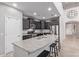 Modern kitchen with dark cabinetry, granite countertops, stainless steel appliances, a large island, and a breakfast bar at 10746 W Desert Elm Ln, Peoria, AZ 85383