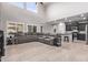 Spacious living room featuring tile floors, large windows, a comfortable seating area, and a view of the kitchen at 10746 W Desert Elm Ln, Peoria, AZ 85383