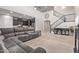 Open concept living room with a fireplace, tile floors, view of the kitchen, and staircase access at 10746 W Desert Elm Ln, Peoria, AZ 85383