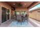 Covered patio with ceiling fan, dining table with seating, and TV at 10746 W Desert Elm Ln, Peoria, AZ 85383