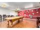 Large billiard room with a pool table, bar stools, wood flooring and decorative pool ball accents on the wall at 11596 W Sierra Dawn Blvd # 293, Surprise, AZ 85378