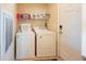 A functional laundry room with a washer, dryer, shelving, and access to an exterior door at 11596 W Sierra Dawn Blvd # 293, Surprise, AZ 85378