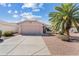 Charming single-story home with a desert landscape, a large palm tree, and a two-car garage at 1433 E Indian Wells Dr, Chandler, AZ 85249