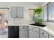 Efficient kitchen with gray cabinets, a black dishwasher, and a window with a hanging plant at 1433 E Indian Wells Dr, Chandler, AZ 85249