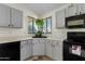 Modern kitchen with gray cabinetry, black appliances, a corner sink, and a hanging plant at 1433 E Indian Wells Dr, Chandler, AZ 85249