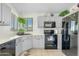 Bright kitchen featuring gray cabinetry, black appliances, and a window with a hanging plant at 1433 E Indian Wells Dr, Chandler, AZ 85249