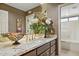 Bathroom vanity with granite counters, fresh flowers, and view to bathtub with shower at 15755 E Palomino Blvd, Fountain Hills, AZ 85268