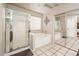 Well-lit bathroom with a glass-enclosed shower, soaking tub, and mirrored closet, offering a spa-like experience at 16292 N Naegel Dr, Surprise, AZ 85374