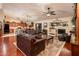 Open-concept living area featuring a fireplace, comfortable furniture, and dark wood floors at 16292 N Naegel Dr, Surprise, AZ 85374
