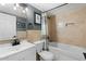 Bathroom featuring a shower-tub combo, updated vanity, framed mirror, and neutral tile at 17234 N Paradise Park Dr, Phoenix, AZ 85032