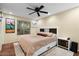Cozy bedroom with a plush bed, ceiling fan, and large window offering natural light, plus decorative bedside tables at 17234 N Paradise Park Dr, Phoenix, AZ 85032