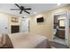Well-lit bedroom featuring a comfortable bed, ceiling fan, and an en-suite bathroom, plus neutral walls at 17234 N Paradise Park Dr, Phoenix, AZ 85032